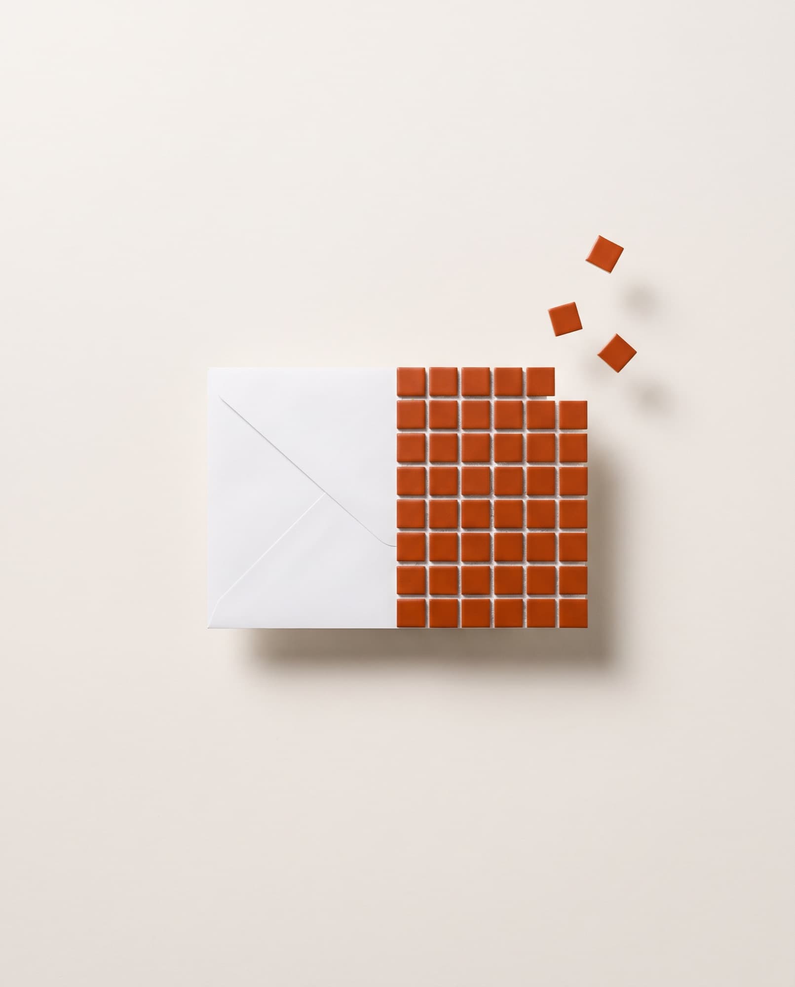 Envelope branco cuja metade direita se desfaz em pequenos quadrados laranja